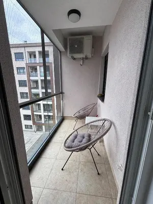 a room with a balcony with a chair and a window at Central Luxe in Banja Luka