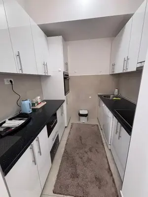 a kitchen with white cabinets and a black counter top at Central Luxe in Banja Luka