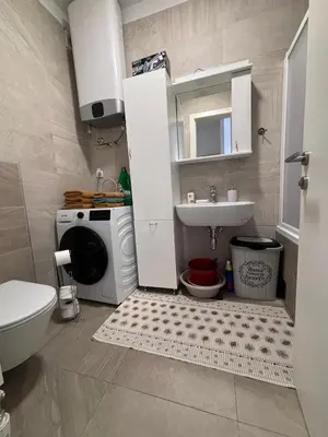 a bathroom with a sink and a washing machine at Central Luxe in Banja Luka