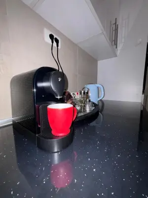 a microwave sitting on a counter with a red cup at Central Luxe in Banja Luka