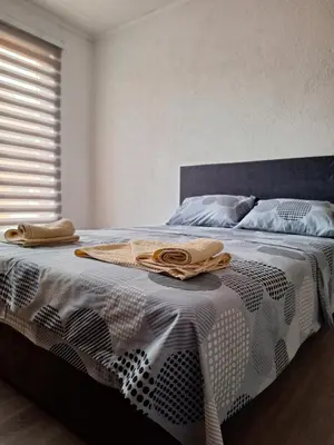 a bed with a black and white blanket and a window at Bloom in Šipovo