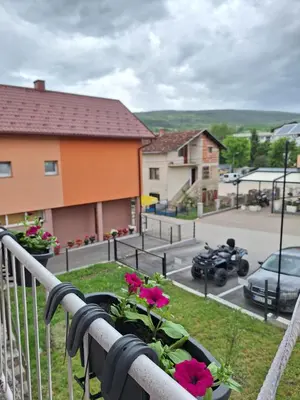 a balcony with pink flowers in a flower pot at Bloom in Šipovo