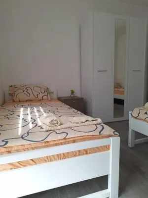 a bedroom with a white bed with a wooden frame at Bloom in Šipovo