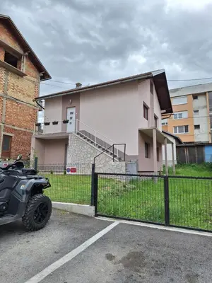 a motorcycle parked in a parking lot in front of a house at Bloom in Šipovo