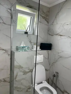 a white bathroom with a toilet and a window at Apartman Rawda 2 in Jajce