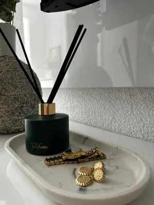 a table with a plate with gold jewelry and a vase at Apartman Rawda 2 in Jajce