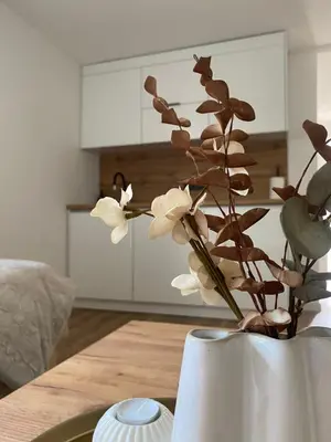a white vase with flowers in it on a table at Apartman Rawda 2 in Jajce
