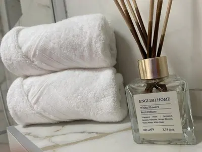 a stack of towels sitting next to a bottle of towels at Apartman Rawda 2 in Jajce