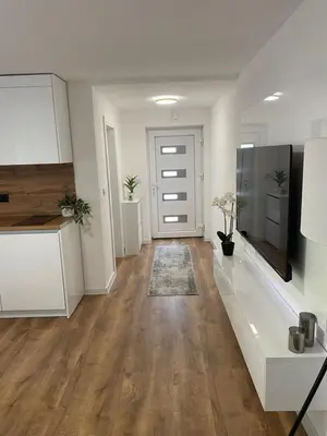 an empty living room with white cabinets and a television at Apartman Rawda 2 in Jajce
