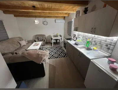 a kitchen and living room with a couch and a table at Holiday Home AZER in Visoko