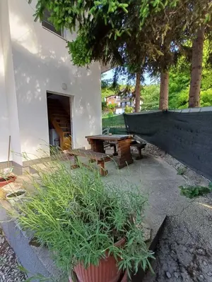 a patio with a table and a bench and some plants at Holiday Home AZER in Visoko