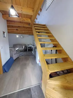 a wooden staircase in a living room with a couch at Holiday Home AZER in Visoko