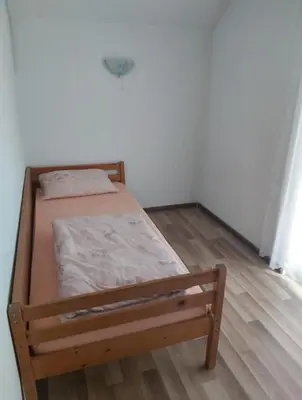 a small bed in a room with a wooden floor at 