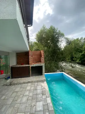 a swimming pool next to a building with a brick fireplace at 