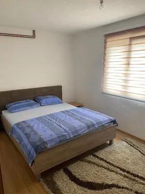 a bedroom with a bed with blue sheets and a window at 