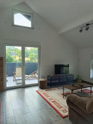 a living room with a couch and a tv at Zen Loft in Tuzla