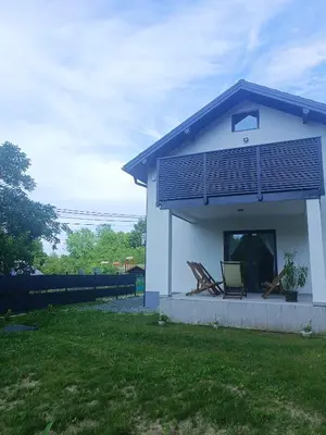 a white house with a balcony and a lawn at Zen Loft in Tuzla