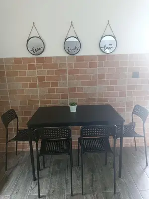 a black table with chairs and two mirrors on the wall at Zen Loft in Tuzla