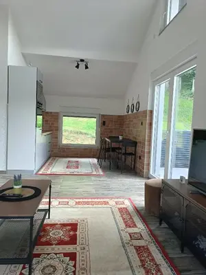 a living room with a tv and a table at Zen Loft in Tuzla