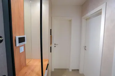 a hallway with a door and a tv on the wall at Elegance Apartmani Doboj Stan na dan in Doboj