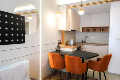a kitchen with a black table and orange chairs at Elegance Apartmani Doboj Stan na dan in Doboj