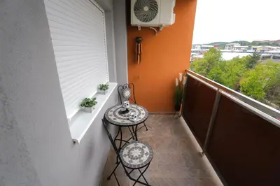 a balcony with a table and two stools on it at Elegance Apartmani Doboj Stan na dan in Doboj