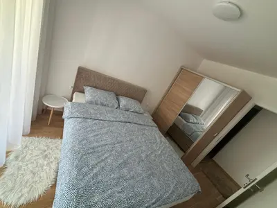 a bedroom with a bed and a mirror at Stan na dan Santo in Banja Luka