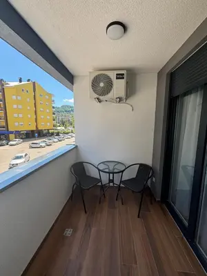 a table and two chairs in a room with a window at Stan na dan Santo in Banja Luka