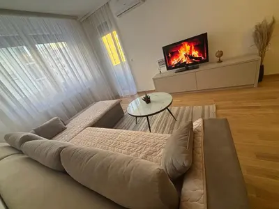 a living room with a couch and a tv at Stan na dan Santo in Banja Luka