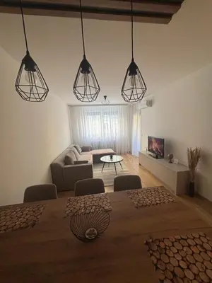 a living room with a table and several lights at Stan na dan Santo in Banja Luka