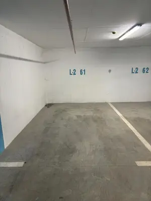 an empty parking garage with white walls and concrete floors at Stan na dan Santo in Banja Luka