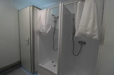 a white bathroom with a shower and white towels at Camp Tommy in Jaklići