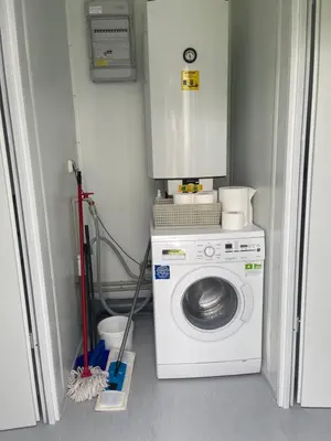 a laundry room with a washing machine and a washer at Camp Tommy in Jaklići