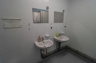 a white bathroom with two sinks and a mirror at Camp Tommy in Jaklići