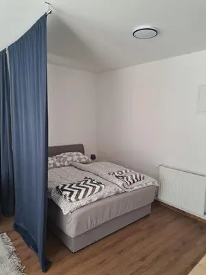 a bedroom with a bed with a blue curtain at Ina in Kupres