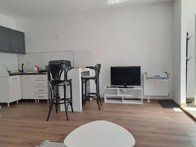 a kitchen with stools and a table and a television at Ina in Kupres