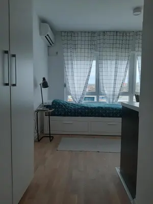 a bedroom with a bed with a window and a desk at Urban Studio Apartment in Tuzla