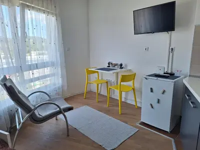 a room with a table and two chairs and a tv at Urban Studio Apartment in Tuzla