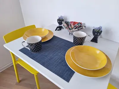 a table with two plates and two cups on it at Urban Studio Apartment in Tuzla