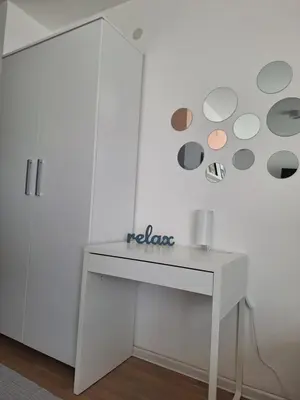 a white desk in a room with a white wall at Urban Studio Apartment in Tuzla