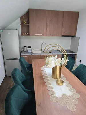 a kitchen with a table with a vase of flowers on it at Apartmani Zlatna Kruna in Banja Luka