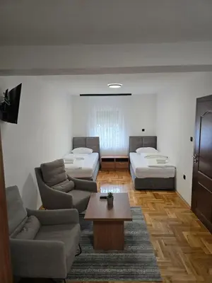 a room with two beds and a couch and a table at Apartmani Zlatna Kruna in Banja Luka