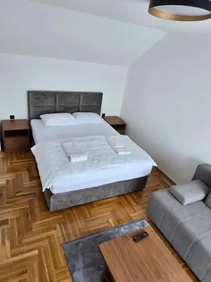 a bedroom with a bed and a couch at Apartmani Zlatna Kruna in Banja Luka