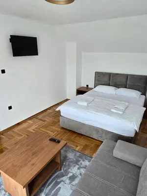 a bedroom with a large bed and a couch at Apartmani Zlatna Kruna in Banja Luka