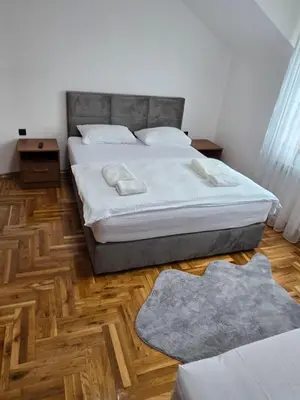 a bedroom with a bed and a wooden floor at Apartmani Zlatna Kruna in Banja Luka