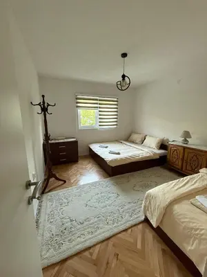 a bedroom with two beds and a large rug at Comfort house near pyramids II in Visoko
