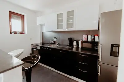 a kitchen with a black counter and a refrigerator at Apartman Deja vu in Livno