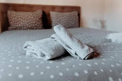 a pile of towels sitting on top of a bed at Apartman Deja vu in Livno