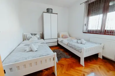 two beds in a room with two windows at Apartman Deja vu in Livno