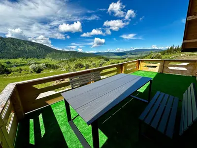a picnic table on the balcony of a house at Vlasic Odmor - Villa Vlasicka Bajka in Vlasic